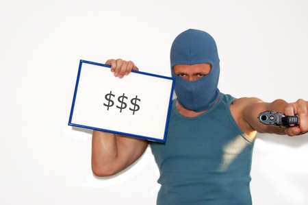 A hooded bank robber holds up a signboard with dollarsの写真素材