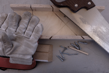 Tool still life with saw, a miter box and skirting board