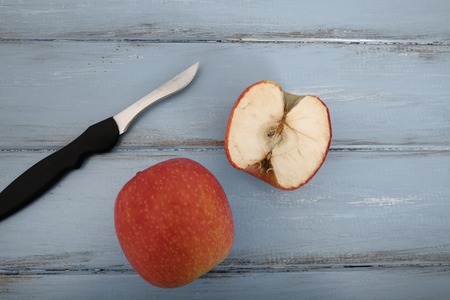 A whole and sliced dry apple over rustic blue background