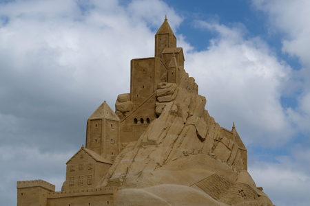 A castle built of sand with sky and clouds in the backgroundの写真素材