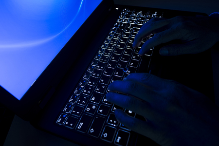 Detail of male hands in the evening at the laptop