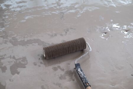 Spiked roller over liquid floor leveling compound for house renovationの写真素材