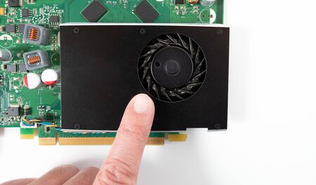A finger points to the dusty cooling fan in the graphics card