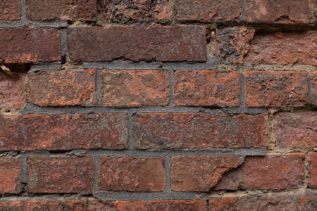 An old, peeled wall of red bricks.