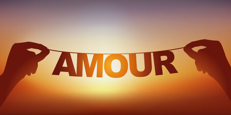 The silhouette of the word love written in loose letters on a garland facing a sunset.のイラスト素材