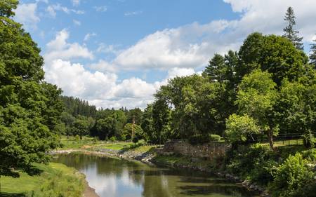 This image was taken from the Woodstock Middle Bridge showing a tranquil river wandering through the Vermont greenery の写真素材