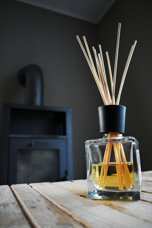 A lovely colored fragrance bottle standing on handmade shaky table by a 5 year old boy in front of an oven.の写真素材