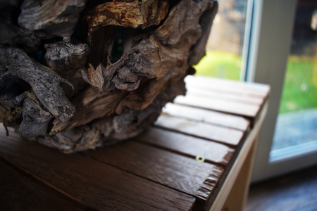Wooden candle holder that stands on a shaky table handmade by a 5 year old boy in a living room of a lovely family.の写真素材