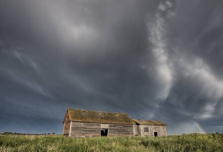 Abandoned Farm with storm clouds in the Canadian Prairieの写真素材