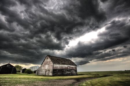 Storm Clouds Saskatchewan old farm and darkened skiesの写真素材