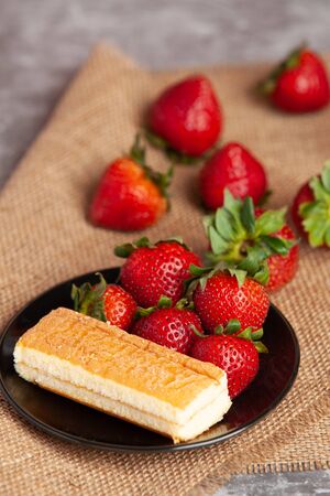 Arrange the strawberries beside the bread on the color plate.の写真素材