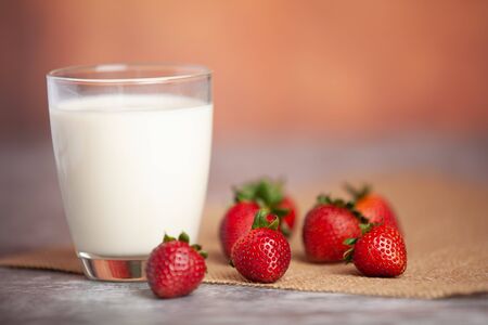Strawberries arranged in pairs of bright white milk cupsの写真素材