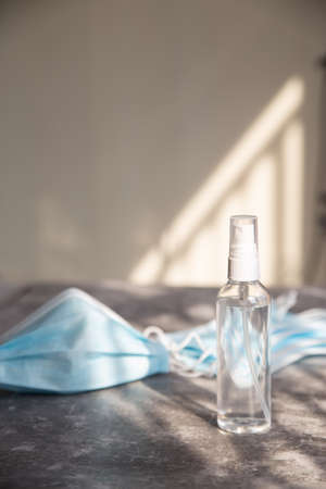 Face mask and alcohol bottle on Gray marble backgroundの写真素材