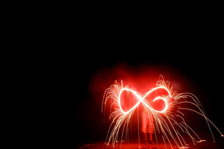 Beautiful red colored sparkle stick in the hand of boy waving it during celebrating Diwali festival...