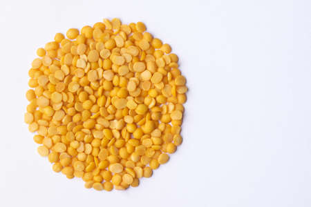Dry Pigeon Pea pulses split into half and spread in circular shape on white background. This is used...