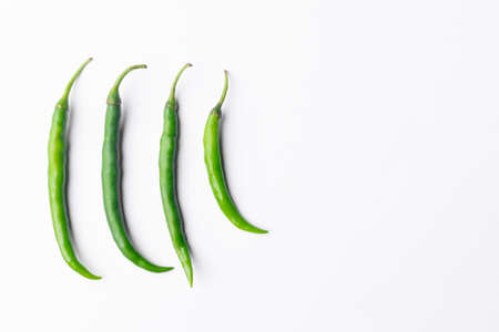 Four Green chilli peppers isolated in white colored background