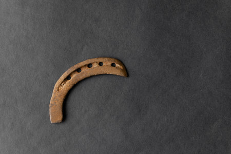 Old rusty horse shoe on black colored background. It is used for to protect a horse hoof from wear.の写真素材
