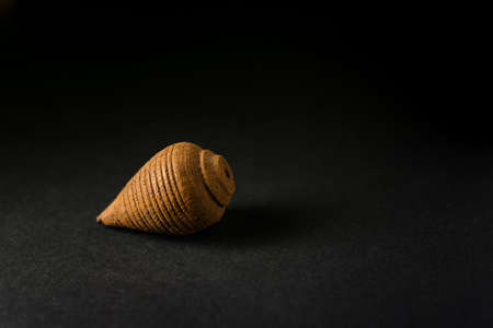 Kids old toy known as Top which is handmade by using wood material isolated in black background. Used selective focus.の写真素材