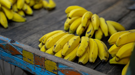 Fresh Banana bunches kept on wooden surface in fruit market. Selective focus.の写真素材