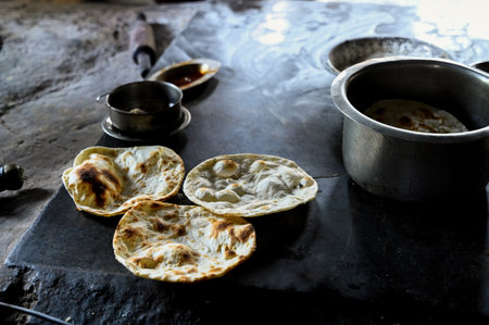 Three Tandoor roti freshly made to serve in the punjabi dhaba with utensils near it. Selective focus.の写真素材