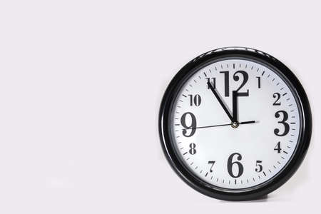 black clock with white dial shows five to twelve isolated on white backgroundの写真素材