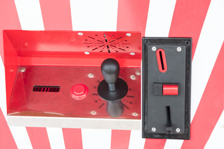 Coin slot and joystick of red and white arcade slot machine