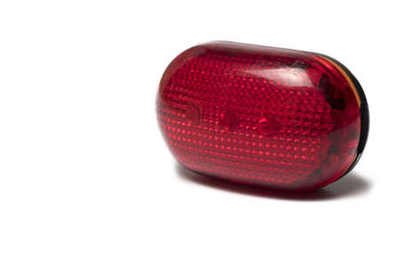 Close up of used rear bicycle reflector lamp in red isolated on white backgroundの写真素材