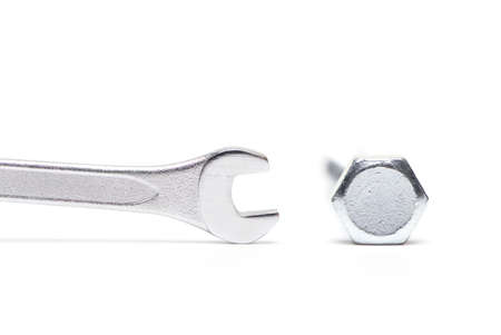 Close up of very small open end wrench next to mismatched large hex bolt as concept of mismatched...