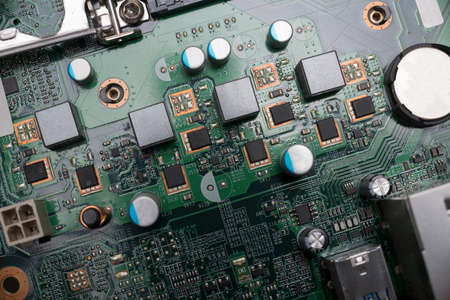 Close-up of a computer board with various solder joints, capacitors, transistors and chips