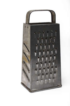 Close up of an old metal spice grater with rounded handle isolated on white backgroundの写真素材