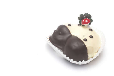 Close up of sweet dessert in the shape of horseshoe with lucky mushroom and four leaf clover on it as lucky charm for New Year isolated on white backgroundの写真素材