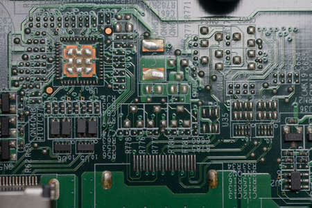 Closeup of computer board with various solder joints, capacitors, transistors and chipsの写真素材