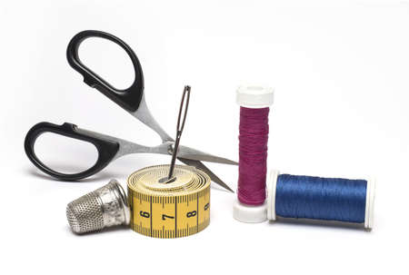 Close up of sewing kit scissors sewing needle different rolls of sewing thread and a thimble on...