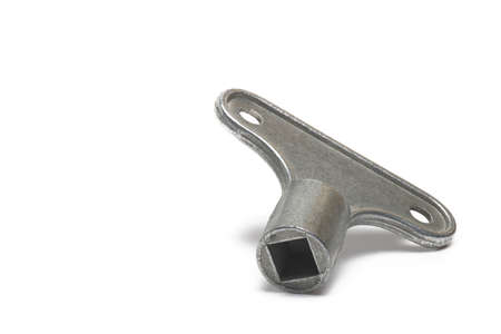 Close up of small metal square key for venting radiators and unlocking square locks on white...