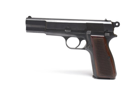 Close up of semi-automatic pistol with wooden grip panels on the grip and black barrel white backgroundの写真素材