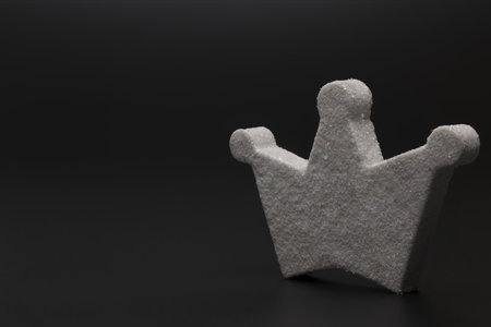 Close up of artificial glittery white crown with three prongs on black background as a concept for king and birthdayの写真素材