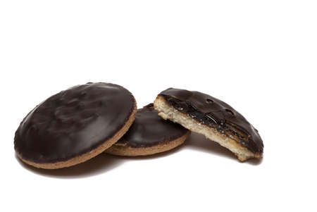 Close up of whole and halves of orange filled chocolate covered cookies on white backgroundの写真素材