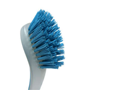 partial close up of blue plastic hand brush for cleaning dishes pots and pans in the kitchen on...