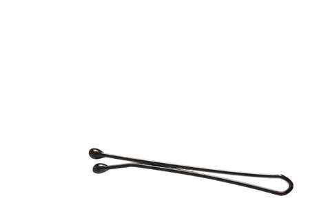 Close up of small used dark hairpin on white background as concept for hair care and putting up long hairの写真素材