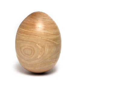 Close up of large hardwood turned Easter egg with clearly visible wood grain on white backgroundの写真素材