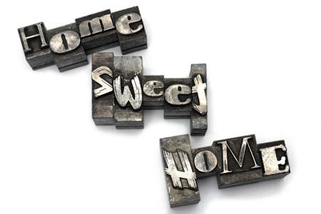 Close up of heavily used old lead letters from print shop depicting home sweet home on white backgroundの写真素材