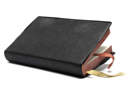 Close up of very old black book bound with leather cover singing book with ribbons for insertion...