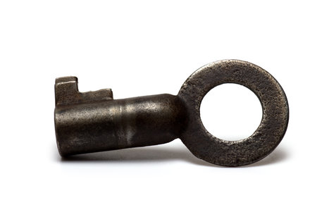 Close up of old rusty retro vintage small key for u-locks shackle against white backgroundの写真素材