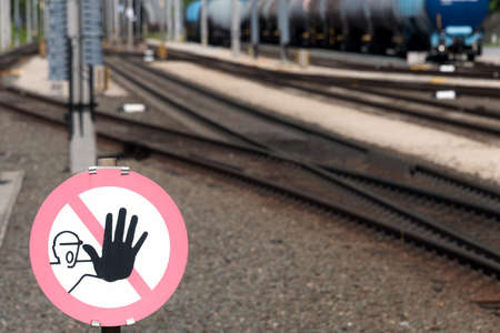 clearly visible danger sign stop danger with railroad tracks rails and train in blurred background...