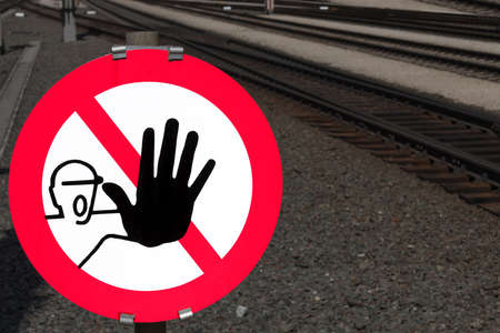 Close up of signal color red danger stop sign with black hand as a clear indication prohibition not to enter railroad tracks and railway facilities as a concept of danger in railroad trafficの写真素材