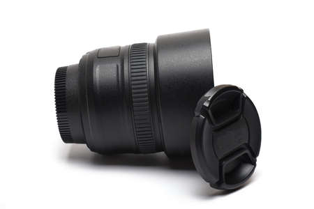 Close-up of a high quality small fixed focal length portrait photo lens with lens hood lens cap and focus ring on white backgroundの写真素材