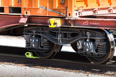 close up partial view of front with buffers of low-floor container wagon on a sunny day on railroad...