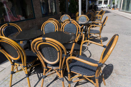 empty tables and chairs seats in front of restaurant bar snack diner beer garden bistro terrace on street on sunny day outdoor as concept for bankruptcy and closures in restaurant industryの写真素材