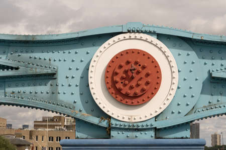 Close up of blue turquoise white red color painted old bracket of steel cables at Tower Bridge in London against cloudy skyの写真素材