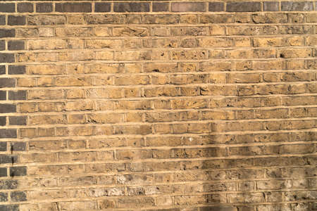 Detail of brick wall built with yellow bricks well visible texture and joints to use as backgroundの写真素材
